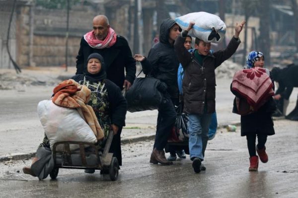 A man pushes a woman on a cart as they flee deeper with others into the remaining rebel-held areas of Aleppo, Syria. REUTERS/Abdalrhman Ismail