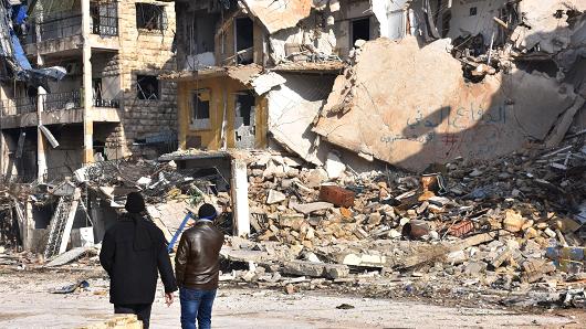 Syrians walk through the former rebel-held Zebdiye district in the northern Syrian city of Aleppo on December 23, 2016.