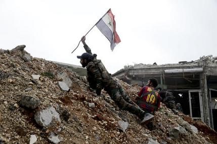  In this Monday, Dec. 5, 2016 file photo, a Syrian army soldier places a Syrian national flag during a battle with rebel fighters at the Ramouseh front line, east of Aleppo, Syria. Aleppo is set to be recaptured by Syrian President Bashar Assad, but the victory will not be Assad's alone. The battle for Syria's largest city has attracted thousands of foreign forces, including Russian soldiers and thousands of fighters from Iran, Lebanon, Iraq and Afghanistan. (AP Photo/Hassan Ammar, File)