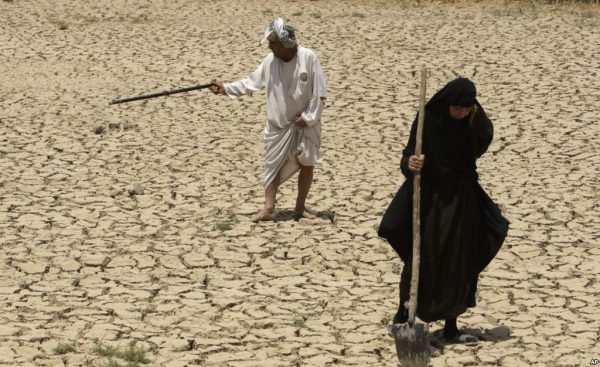 An older couple walks across their dried up farmland (Photo: AP)