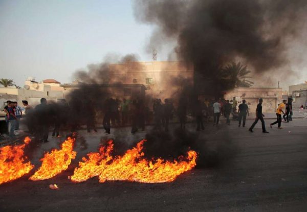 FILE- In this Friday, March 14, 2014 file photo, Bahraini anti-government protesters burn representations of the flag of Gulf countries' Peninsula Shield forces, during a protest in Malkiya, Bahrain. Bahraini authorities say they have put to death three men found guilty of a deadly attack on police, the kingdom's first executions since an Arab Spring-inspired uprising rocked the country in 2011. less