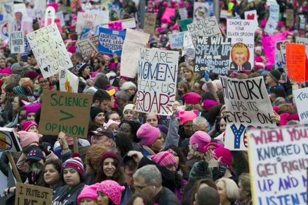 Women with bright pink hats and signs begin to gather early and are set to make their voices heard on the first full day of Donald Trump's presidency, January 21, 2017 in Washington. AP Photo/Jose Luis Magana