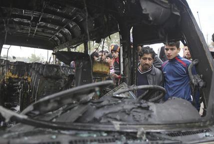 Citizens inspect the scene after a car bomb explosion at a crowded outdoor market in the Iraqi capital's eastern district of Sadr City, Iraq, Monday, Jan 2, 2017. A suicide bomber blew up his explosives-laden vehicle Monday in a bustling market area in Baghdad, killing at least a dozen people, Iraqi officials said, hours after the arrival of French President Francois Hollande to the country and amid a fierce fight against the Islamic State group. (AP Photo/ Karim Kadim)