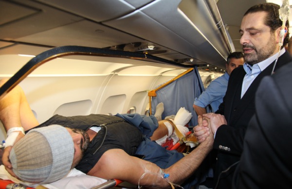 Prime Minister Saad Hariri is shown inside the plane with one of the wounded Lebanese 