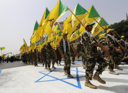 FILE - Iraqi Shi'ite Muslim men from the Iranian-backed group Kataib Hezbollah wave the party's flags as they walk along a street painted in the colours of the Israeli flag during a parade marking the annual Quds Day, or Jerusalem Day, on the last Friday of the Muslim holy month of Ramadan, in Baghdad July 25, 2014. REUTERS/Thaier al-Sudani