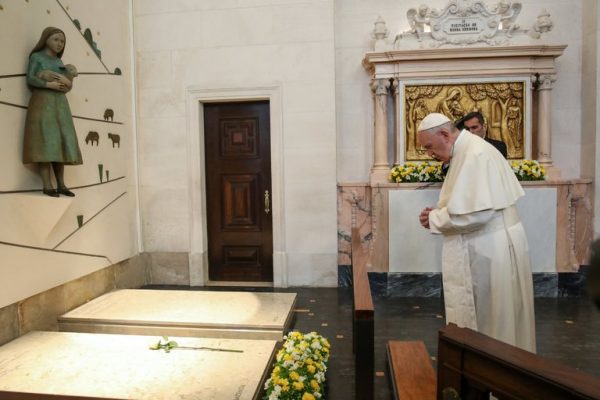 Pope Francis praying at the grave of Jacinta and Francisco Marto at the Our Lady Rosario Cathedral in the Fátima Sanctuary in Leiria, Portugal, on Saturday. Credit Pool photo by Paulo Cunha 