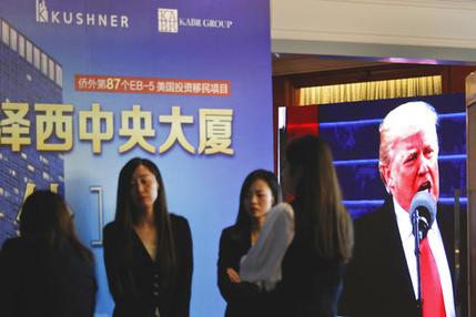 A projector screen shows a footage of U.S. President Donald Trump as workers wait for investors at a reception desk during an event promoting EB-5 investment in a Kushner Companies development at a hotel in Shanghai, China, Sunday, May 7, 2017. The sister of President Trump's son-in-law, Jared Kushner, has been courting Chinese investors using a much-criticized federal visa program that provides a path toward obtaining green cards. (AP Photo)