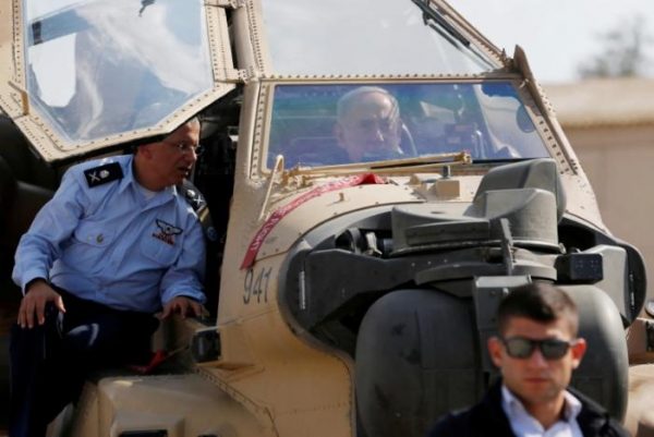  FILE PHOTO: Israeli Prime Minister Benjamin Netanyahu sits inside an Apache Helicopter next to Chief of the Israeli Air Force Major-General Amir Eshel (L) during his visit to the Tel Nof airforce base in southern Israel August 17, 2016. REUTERS/Amir Cohen/File Photo