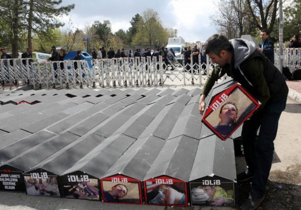 A man carries one of the symbolic coffins with pictures of Syrian victims and inscriptions which translates as "killer Assad" and "killer Putin" set up during a protest against Russia for its alleged role in a chemical attack in the Syrian province of Idlib, on April 7 in Ankara. (Adem Altan/AFP/Getty Images)