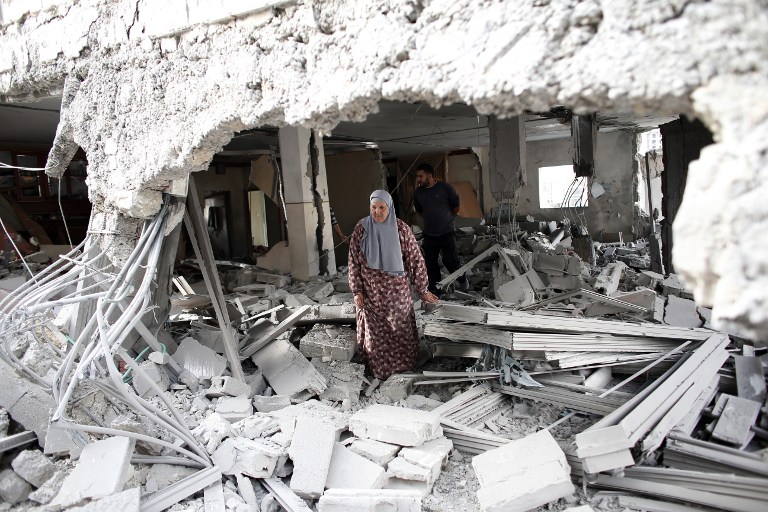 A Palestinian woman walks amid the rubble of a house after Israeli security forces demolished the homes of two Palestinians in east Jerusalem, 