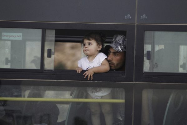 A Syrian man with a child is seen in a bus in Jroud Arsal, Lebanon August 2017. REUTERS/Mohamed Azakir