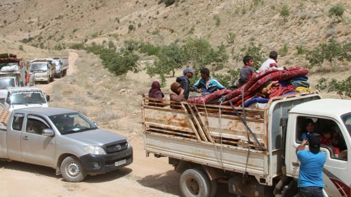 Syrian refugees ride vehicles in the Lebanese eastern border town of Arsal. Lebanon hosts 1.5m people who have fled Syria's six-year war © AFP