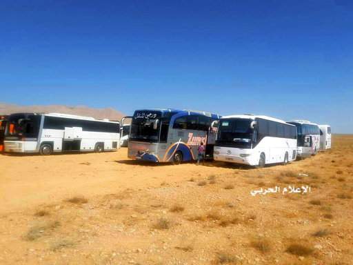  This photo provided on Monday, Aug 28, 2017 by the government-controlled Syrian Central Military Media, shows buses gathering before a planned evacuation of Islamic State group militants, in the mountainous region of Qalamoun, Syria. The remains of eight Lebanese soldiers kidnapped by the Islamic State group three years ago were located Sunday, a senior Lebanese official said, in a Hezbollah deal that followed a military offensive to drive the militants out of the border area with Syria. The deal angered many in Iraq and Lebanon . "Shame on a nation whose soldiers return in coffins, while the criminals leave in air-conditioned buses," many outraged Lebanese posted on social media.(Syrian Central Military Media, via AP) The Associated Press