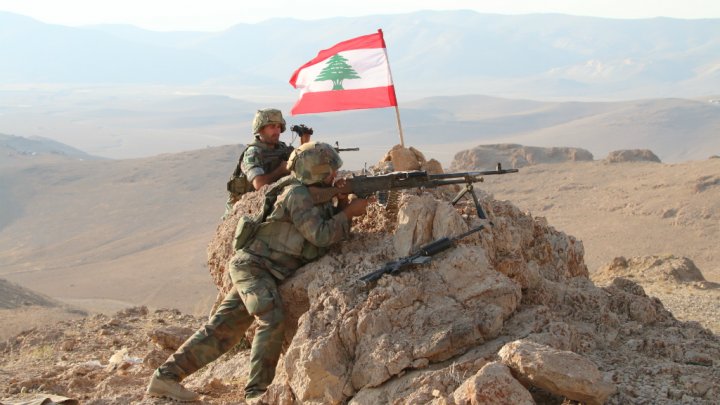 Lebanese army soldiers position the Lebanese flag on top of a hill in the town of Ras Baalbek that the army recaptured from ISIS , Lebanon August 21, 2017.