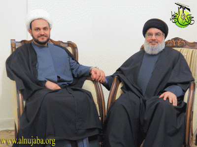 Akram Abbas al Kaabi, the Secretary General of the Harakat Nujaba, holds hands with Hassan Nasrallah, the leader of Lebanon's Hezbollah. Image from the League of the Righteous’s website.