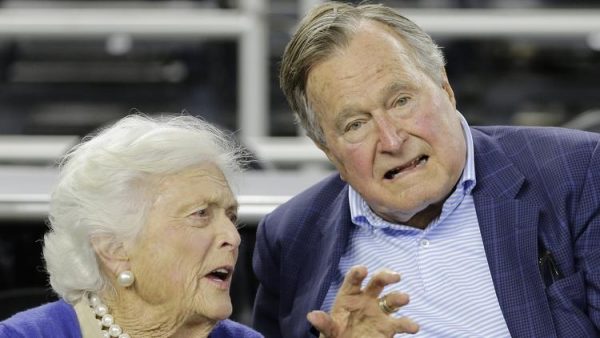 Former President George H.W. Bush and his wife Barbara Bush speak before the first half of a college basketball game in Houston on March 29, 2015. (David J. Phillip / AP)