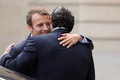 French President Emmanuel Macron (L) hugs Lebanese Prime Minister Saad Hariri after their meeting at the Elysee Palace in Paris on September 1, 2017. / AFP PHOTO / ludovic MARIN