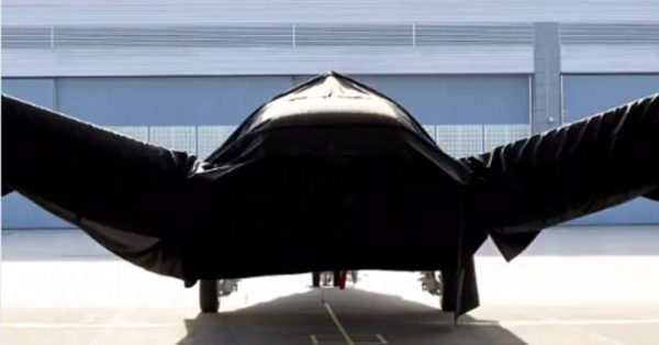 The craft, seen hidden under a black cover, is believed to be a radical new craft using electric 'hairdryer' to allow it to land and take off vertically. 