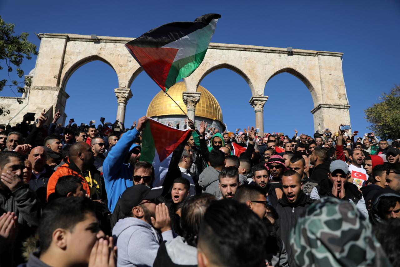 Worshippers chant as they wave Palestinian flags after Friday prayers on the compound known to Muslims as Noble Sanctuary   in Jerusalem's Old City, as Palestinians call for a "day of rage" in response to U.S. President Donald Trump's recognition of Jerusalem as Israel's capital December 8, 2017. REUTERS/Ammar Awad