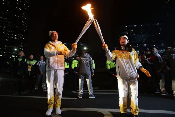South Korean actor Park Bo-Gum, left, holds the PyeongChang 2018 Winter Olympics torch during the torch relay in Seoul on Jan. 16, 2018. Photographer: Chung Sung-Jun/Getty Images AsiaPac