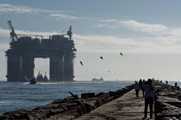 Tug boats pulled a Chevron drilling platform toward the Gulf of Mexico in 2013. The Trump administration said Thursday it would open most of the country’s offshore waters to oil and gas drilling. Credit Eddie Seal/Bloomberg, via Getty Images 