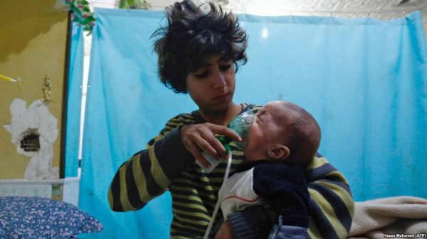 A Syrian boy holds an oxygen mask on an infant at a makeshift hospital after a reported gas attack on the rebel-held town of Douma in the Eastern Ghouta region on the outskirts of Damascus on Jan. 22. (Hasan Mohamed/AFP) 