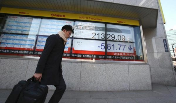 A man walks by an electronic stock board of a securities firm in Tokyo, Friday, Feb. 9, 2018. Asian shares have opened lower and are tracking the overnight plunge on Wall Street. The Dow Jones industrial average plunged more than 1,000 points as a weeklong market swoon continued. (AP Photo/Koji Sasahara) 