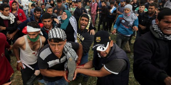 A wounded Palestinian woman is evacuated during clashes with Israeli troops, during a tent city protest along the Israel border with Gaza, demanding the right to return to their homeland, the southern Gaza Strip March 30, 2018. REUTERS/Ibraheem Abu Mustafa