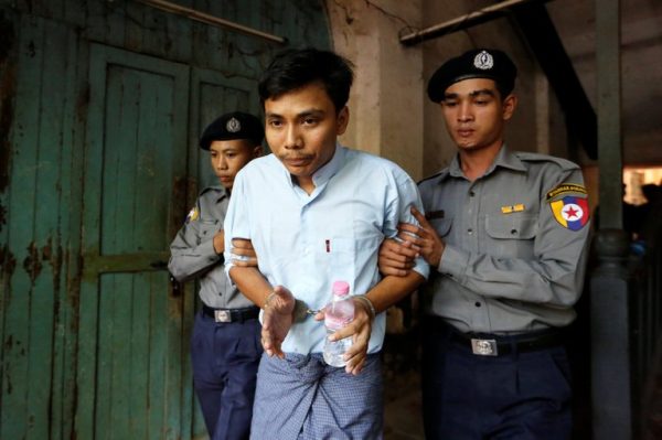 Detained Reuters journalist Kyaw Soe Oo is escorted by police before a court hearing in Yangon, Myanmar April 11, 2018. REUTERS/Ann Wang