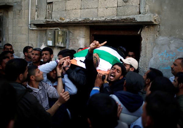 Mourners carry the body of Palestinian Faris al-Reqib, 29, who was killed during clashes at Israel-Gaza border, during his funeral in Khan Younis, in the southern Gaza Strip (photo credit: MOHAMMED SALEM/REUTERS) 