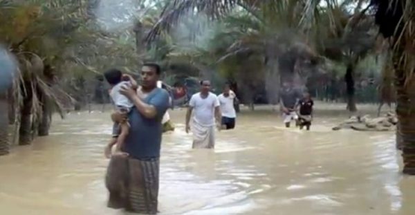 An image grab from AFPTV shows people wading to evacuate a flooded area during a cyclone on the Yemeni island of Socotra on May 25, 2018