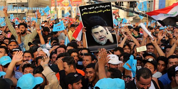Supporters of Muqtada al-Sadr, who is seen on the poster, attend a campaign rally in Baghdad.Karim Kadim / AP file