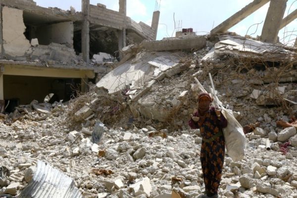  A woman gestures as she stands on rubble of damaged buildings in Raqqa, Syria May 14, 2018. REUTERS/Aboud Hamam/File 