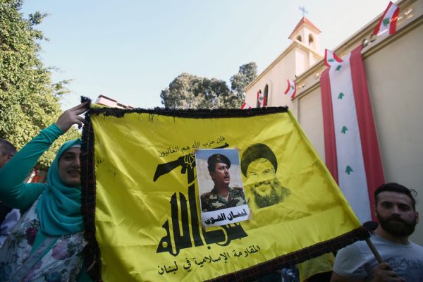 People carry a Hezbollah flag with a picture of newly elected Lebanese President Michel Aoun stuck on it, in the Haret Hreik area, southern suburbs of Beirut, Lebanon October 31, 2016.