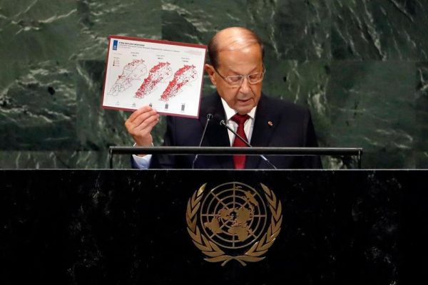 Lebanon's President Michel Aoun holds a map of Syria Refugee Response as he addresses the 73rd session of the United Nations General Assembly, at U.N. headquarters, Wednesday, Sept. 26, 2018. (AP Photo/Richard Drew)