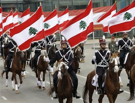 Lebanese Army troops on horseback hold Lebanese flags during a military parade to mark the 69th anniversary of Lebanon's independence from France, in downtown Beirut, Lebanon, Thursday Nov. 22, 2012. Lebanon gained independence from France in 1943. (AP Photo/Hussein Malla)