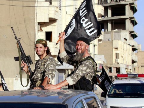 islamic-state-fighters-wave-flags-as-they-take-part-in-a-military-parade-along-the-streets-of-northern-raqqa-province-syria-june-30-2014-reutersstringer