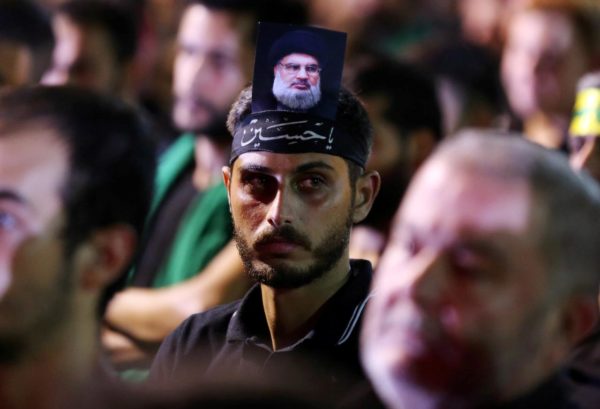 FILE PHOTO: A supporter of Lebanon's Hezbollah leader   Hassan Nasrallah has his picture on his head, during a live broadcast, the night before Muslim Shi'ites around the world mark the day of Ashura, in Beirut, Lebanon September 19, 2018. REUTERS/Hasan Shaaban/File Photo