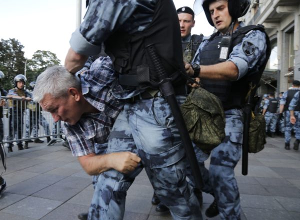 Russia Opposition Protest Police officers detain a man during an unsanctioned rally in the center of Moscow, Russia, Saturday, July 27, 2019. Russian police are wrestling with demonstrators and have arrested hundreds in central Moscow during a protest demanding that opposition candidates be allowed to run for the Moscow city council. (AP Photo/Alexander Zemlianichenko) 