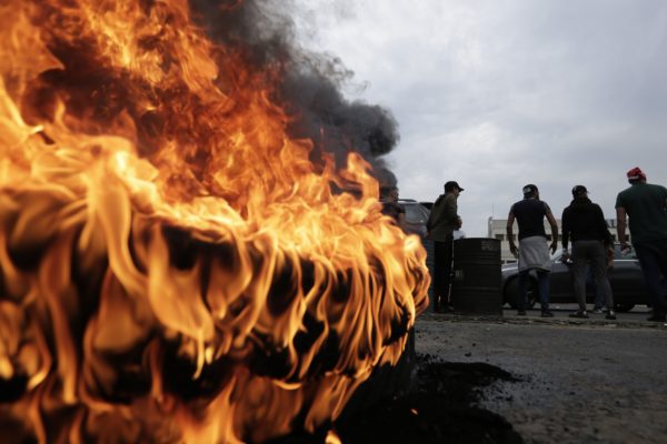 Anti-government protesters set fire to tires blocking a highway that link the Capital Beirut to north Lebanon during a protest against the Lebanese government in Zouk Mosbeh, north of Beirut, Lebanon, Monday, Oct. 28, 2019. (AP Photo/Hassan Ammar)