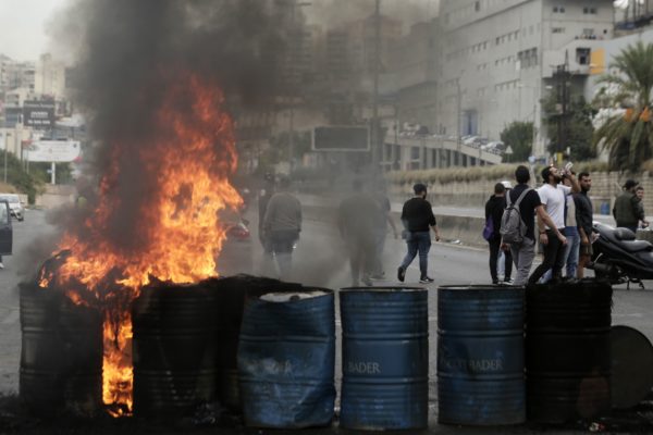 Anti-government protesters set fire to tires to block a highway that links the capital Beirut to northern Lebanon during a protest against the Lebanese government in Zouk Mosbeh, north of Beirut, Lebanon, Monday, Oct. 28, 2019. (AP Photo/Hassan Ammar)