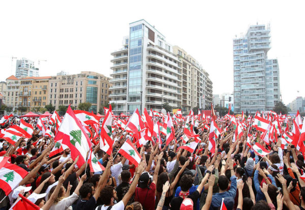 Demonstrators carry the national flags and banners during an anti-government protest in downtown Beirut, Lebanon October 20, 2019. REUTERS/Ali Hashisho