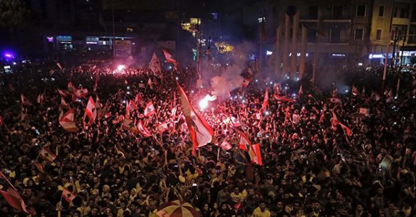 Demonstrators carry the national flags and banners during an anti-government protest in downtown Beirut, Lebanon October 20, 2019. REUTERS/Ali Hashisho