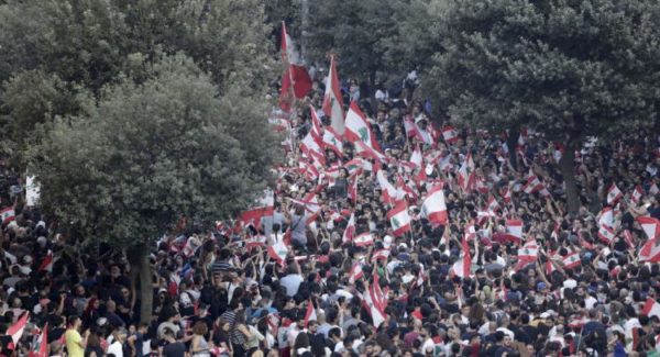 Demonstrators carry national flags and banners during an anti-government protest in downtown Beirut, Lebanon October 21, 2019. REUTERS/Ali Hashisho