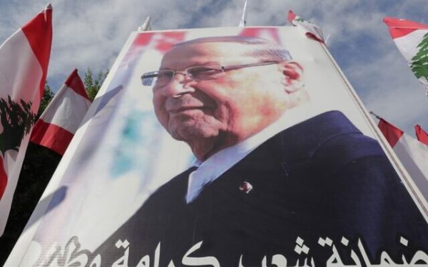 Supporters of Lebanese President Michel Aoun hold a poster of him during a counter-protest near the presidential palace in Baabda on November 3, 2019. - Thousands of Lebanese gathered to show support to the embattled president, an AFP correspondent said, after more than two weeks of mass anti-graft protests that brought down the government. (Photo by ANWAR AMRO / AFP)