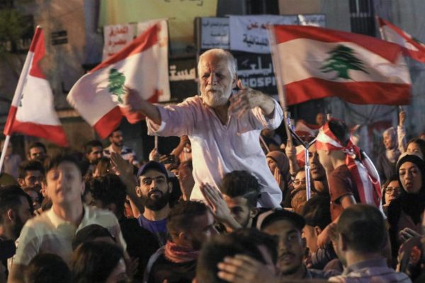 Lebanese protesters chant slogans and wave the flag