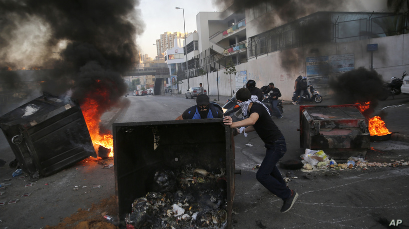 Anti-government protesters block a main highway by a garbage containers and burned tires, during ongoing protests against the Lebanese government, in Beirut, Lebanon, Monday, Nov. 4, 2019. Prime Minister Saad Hariri resigned last week, meeting a key demand of the protesters, but many are calling for more sweeping change. The government proposed a vague roadmap last month aimed at improving the economy, fighting corruption and replacing the sectarian political system with a civil state, but the protests have continued. (AP Photo/Hussein Malla)